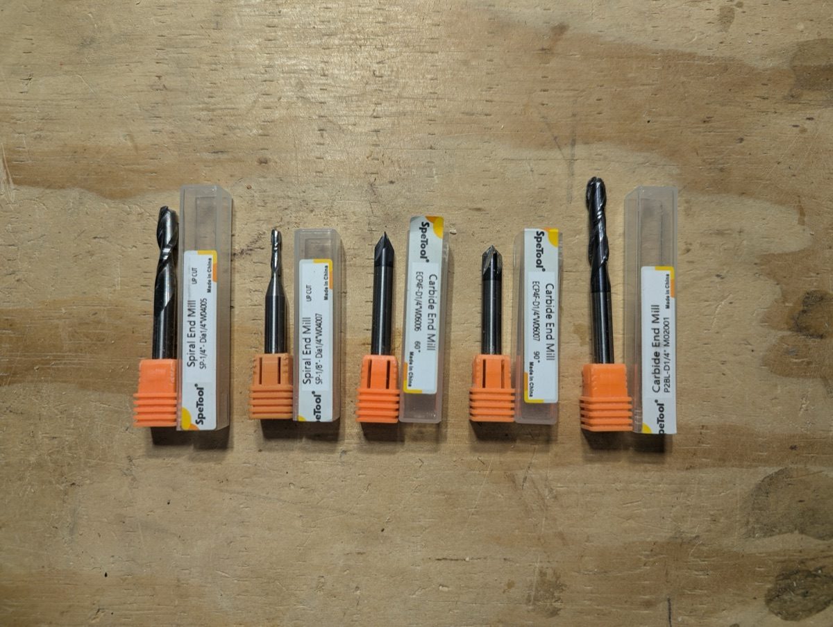 Five essential CNC router bits for beginners arranged on workbench