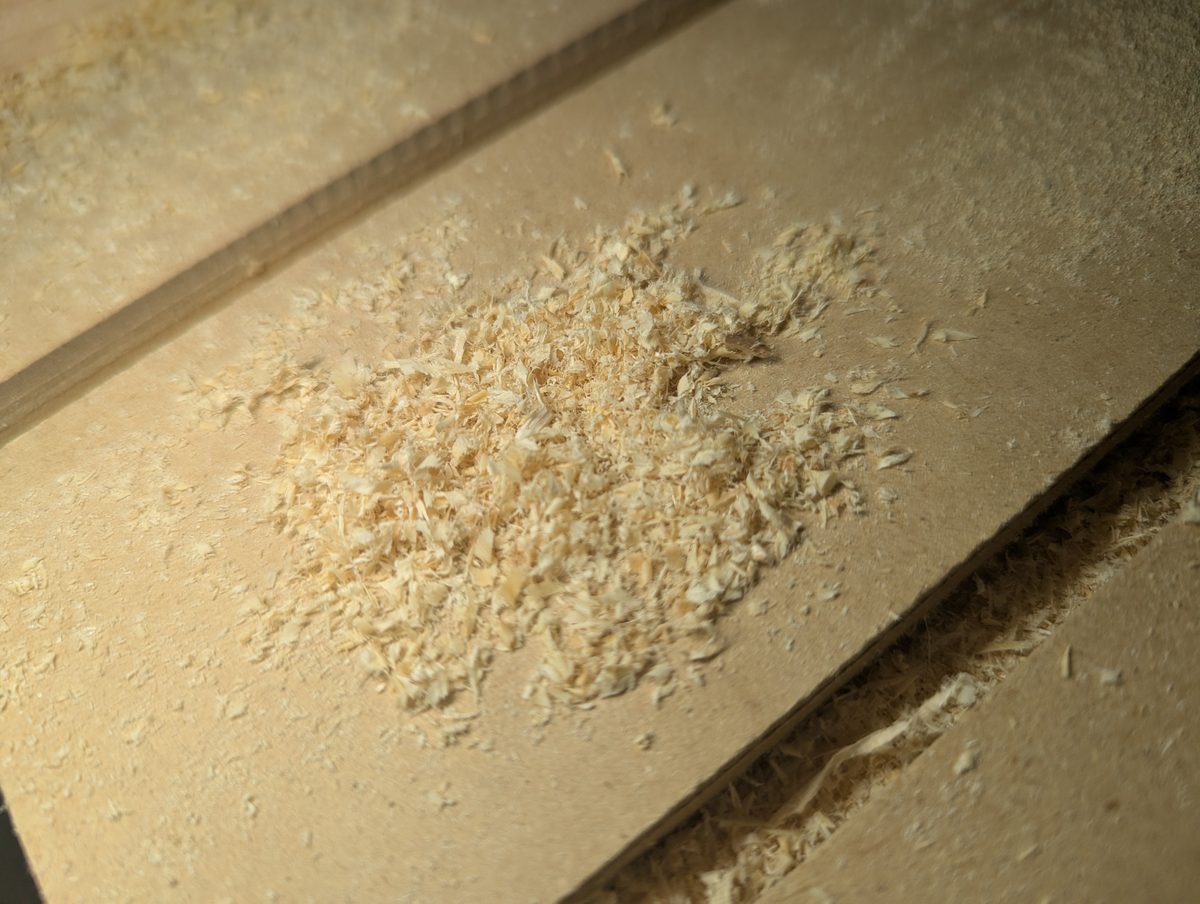 Close-up of small curly chips on CNC bed